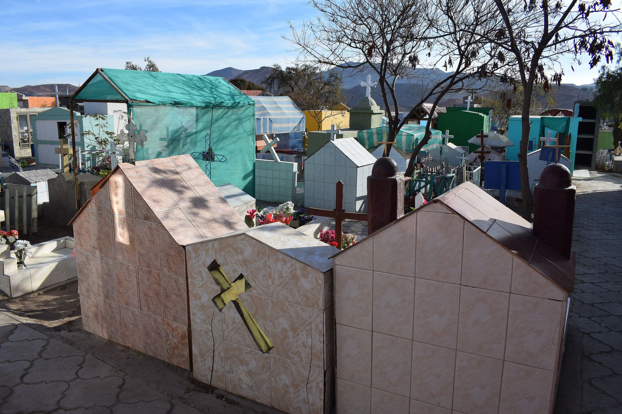 Sepulturas con forma de casita, cruces y cerámica.